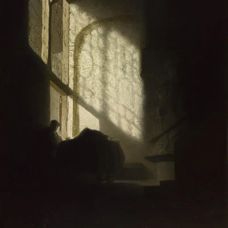A Man seated reading at a Table in a Lofty Room